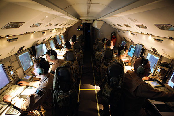 The crew of an E-7A Wedgetail at their consoles during a mission over Iraq.