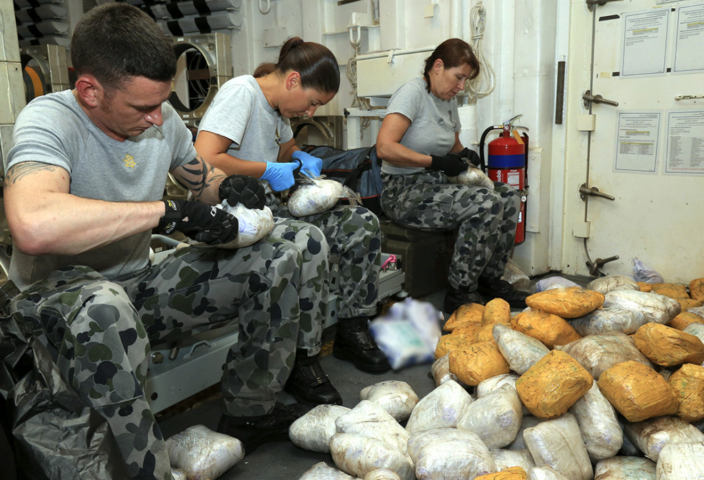 Seized drugs are unwrapped and sorted by HMAS Newcastle crew members. 