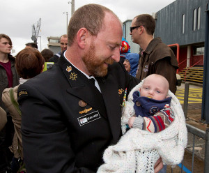 Chief Petty Officer Cryptologic Systems Sean Hardy holds his son for the first time. Photo by Able Seaman Tom Gibson.