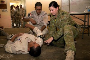 Australian Army trainer Lieutenant Lisa Barker shows how to apply a combat application tourniquet to a simulated casualties’ arm during a first aid lesson at the Taji Military Complex, Iraq. Photo by Captain Bradley Richardson