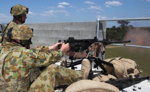 Australian Army soldier Corporal Michael Buxton fires a .50 calibre machine gun from a rooftop.
