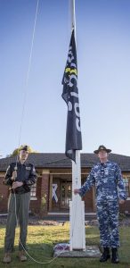 Commander Royal Australian Air Force Air Mobility Group Air Commodore William Kourelakos and Warrant Officer Ian Wheatley hoist the Invictus Games flag at RAAF Base Richmond. Photo by Corporal Casey Forster.