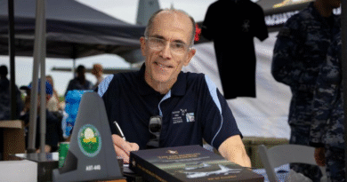 Air Commodore Bill Kourelakos (rtd) signs 'The Air Mobility Workhorse: C-130 Hercules Aircraft in Royal Australian Air Force (RAAF) Service'. Story by Squadron Leader Eamon Hamilton. Photos by Leading Aircraftwoman Aiesha White-Kratz.