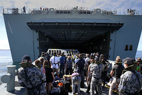 Ship's Company from NUSHIP Adelaide, play the part of civilian evacuees being transported to HMAS Canberra on a landing craft, during an evacuation exercise.