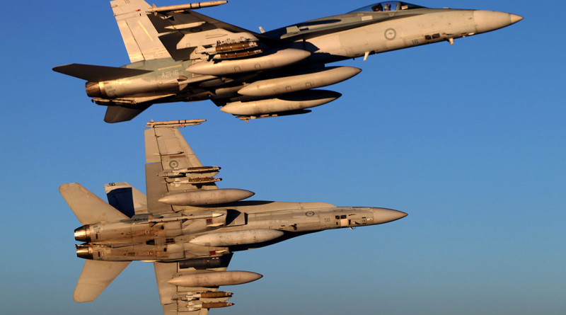 A pair of F/A-18A Hornets bank away from a KC-30A Multi Role Tanker Transport over Iraq.