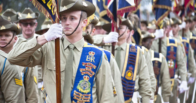 Australian Army soldiers carry 2nd Division unit colours, guidons and banners off the parade ground during the centenary parade at the Australian War Memorial, Canberra.