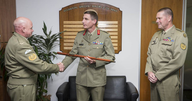 Chief of Army, Lieutenant General Angus Campbell receives the Army Pace Stick from Warrant Officer Dave Ashley at Army Headquarters in Canberra, watched by Warrant Officer Don Spinks