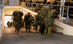 ABOVE: Soldiers from 2RAR embark HMAS Canberra as the ship prepares to sail for Exercise Sea Raider, the last exercise of Sea Series 2015. MAIN: Light Armoured Vehicles from the 2nd Cavalry Regiment drive onboard. Photos by Leading Seaman Helen Frank.