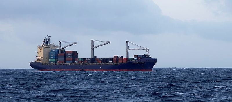 Appearing tiny against the backdrop of a freighter, crew members including the Medical Officer from HMAS Melbourne draw alongside the merchant vessel City of Beijing in Melbourne's sea boat.