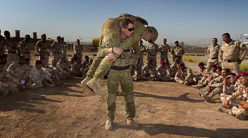 Australian Army trainer Corporal Benjamin Wallis demonstrates how to carry an injured soldier correctly on battlefield during a first aid lesson at the Taji Military Complex, Iraq. Photo by Corporal Oliver Carter.
