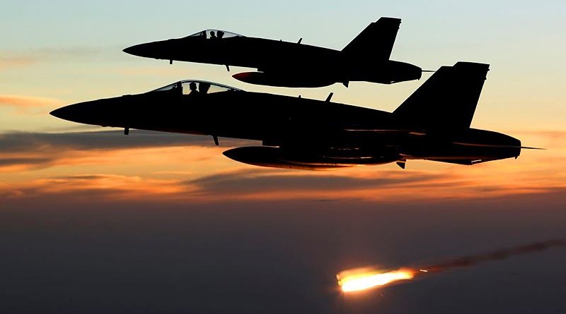 An Australian F/A-18A Hornet relelases a flare at sunset in the skies over Iraq. RAAF photo.