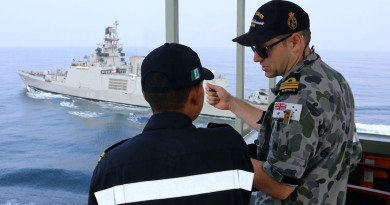 Indian Navy Lieutenant Aravirnd Bhat and Navigating Officer HMAS Sirius, Lieutenant Commander Peter Dargan, discuss the different approaches to at sea replenishment between the Australian and Indian Navies, whilst INS Shivalik prepares to conduct an approach for a practice replenishment. HMAS Sirius and INS Shivalik were taking part in AUSINDEX 15.