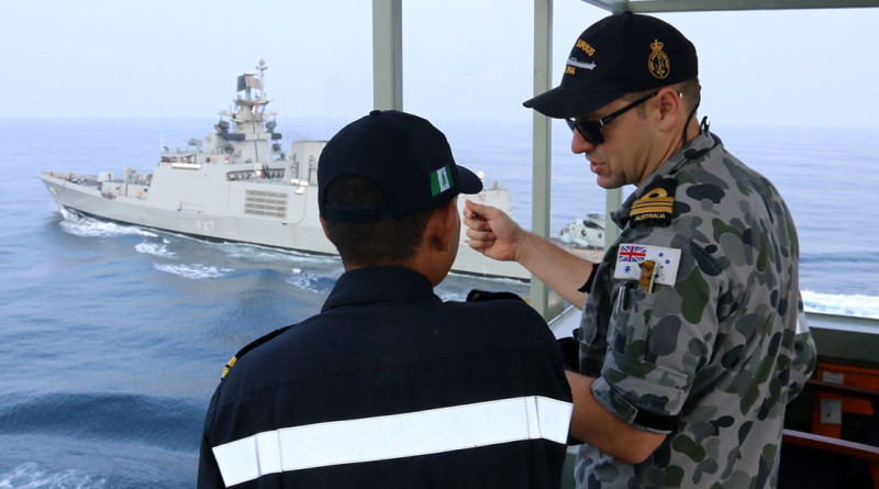 Indian Navy Lieutenant Aravirnd Bhat and Navigating Officer HMAS Sirius, Lieutenant Commander Peter Dargan, discuss the different approaches to at sea replenishment between the Australian and Indian Navies, whilst INS Shivalik prepares to conduct an approach for a practice replenishment. HMAS Sirius and INS Shivalik were taking part in AUSINDEX 15.