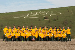 The Australian Services Rugby Union men's team in front of the Anzac Badge carved into the hillside by AIF soldiers stationed in Codford in 1916. Photo by Corporal Janine Fabre.