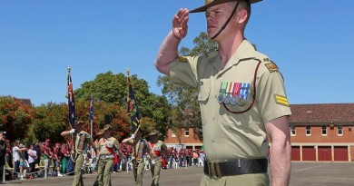 Corporal Donovan Murphy salutes as the colours of 7th Battalion, Royal Australian Regiment