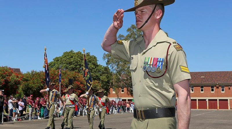 Corporal Donovan Murphy salutes as the colours of 7th Battalion, Royal Australian Regiment