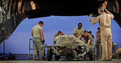 Under direction from a RAAF Loadmaster, American and Australian load team members load military equipment onto a RAAF C-17A Globemaster aircraft in the Middle East Region. Photo by Corporal Ben Dempster