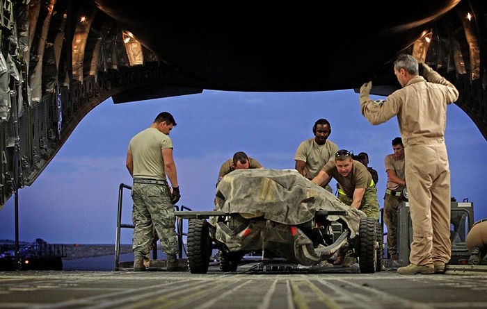 Under direction from a RAAF Loadmaster, American and Australian load team members load military equipment onto a RAAF C-17A Globemaster aircraft in the Middle East Region. Photo by Corporal Ben Dempster