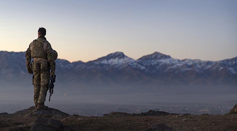 A Danish soldier waits for sunrise on Christmas Eve at the Afghan National Army Officer Academy during a hike to Charandaz peak near Kabul, Afghanistan.