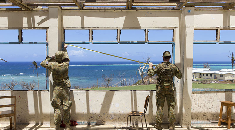 Australian Army Sappers John Corn and Ty Fergus from the 2nd Combat Engineer Regiment, assess a damaged school in the village of Nasau on Koro Island as a part of Operation Fiji Assist.