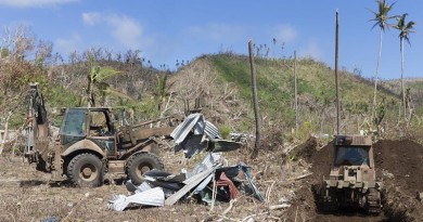 An Australian Army Backhoe gathers debris to be buried as a part of the clean up process of Operation Fiji Assist. Photo by Able Seaman Chris Beerens