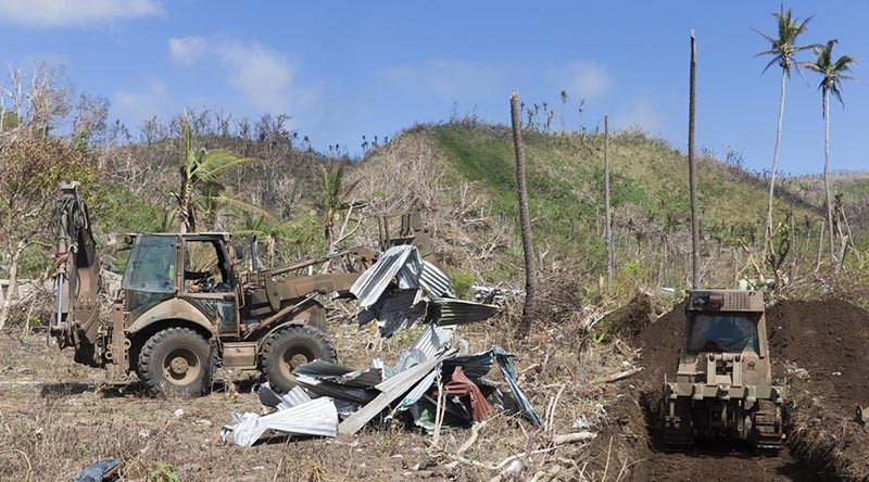 An Australian Army Backhoe gathers debris to be buried as a part of the clean up process of Operation Fiji Assist. Photo by Able Seaman Chris Beerens