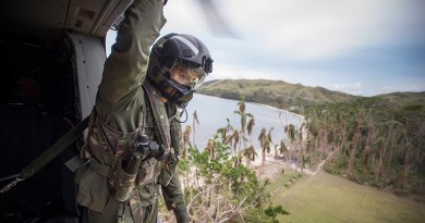 Helicopter Loadmaster, SGT Lyle Wooller looks over the landing zone from a RNZAF NH90 Helicopter lands as it comes in to land to deliver personnel and aid. NZDF photo