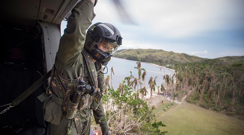 Helicopter Loadmaster, SGT Lyle Wooller looks over the landing zone from a RNZAF NH90 Helicopter lands as it comes in to land to deliver personnel and aid. NZDF photo