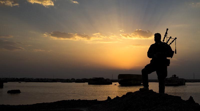 Australian soldier Corporal Kenneth Horton, of Task Group Taji, plays the bagpipes as the sun sets over the Taji Military Complex, Iraq. Photo by corporal Jake Sims