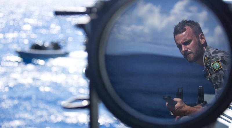 Sub Lieutenant Jackson Miller observes boat evolutions onboard HMAS Wollongong as she saisl across the Arafura Sea. Photo by Able Seaman Kayla Hayes.