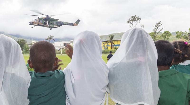 Students from the Rakiraki Muslim Primary School cheer as an Australian Army Taipan MRH-90 helicopter takes off for another mission during Operation Fiji Assist. Photo by Corporal Dan Pinhorn