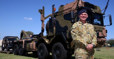 Corporal Grant Solomon, of the Land 121 Driver Training Team, shows off a new Rheinmetall MAN truck following the vehicle’s acceptance under LAND 121 Phase 3B at Gallipoli Barracks. Photo by Corporal Max Bree.