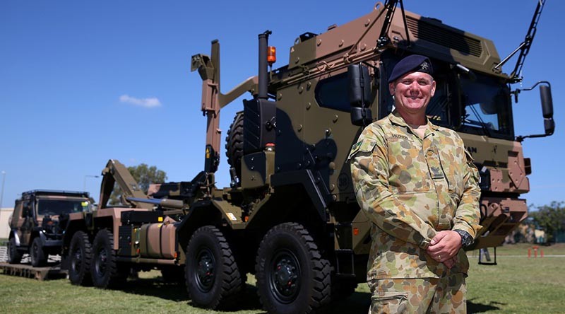 Corporal Grant Solomon, of the Land 121 Driver Training Team, shows off a new Rheinmetall MAN truck following the vehicle’s acceptance under LAND 121 Phase 3B at Gallipoli Barracks. Photo by Corporal Max Bree.