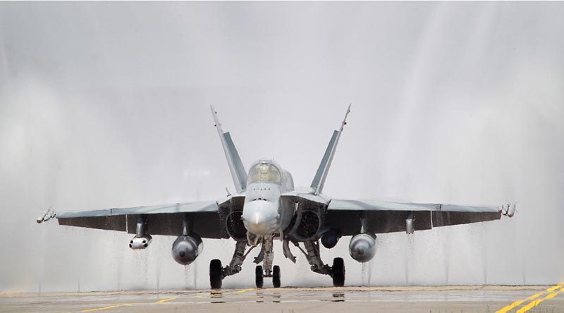 An F/A-18A Hornet goes through a desalination 'bird-bath'. Photo by Corporal Melina Young