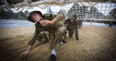 Australian Air Force Cadets Lachlan Bulmer tackles an obstacle during battle PT in the Canberra cold and rain at the Australian Defence Force Academy.