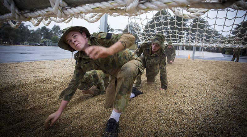 Australian Air Force Cadets Lachlan Bulmer tackles an obstacle during battle PT in the Canberra cold and rain at the Australian Defence Force Academy.