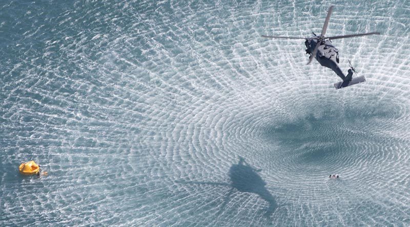 A United States HH-60 Pave Hawk search and rescue helicopter winches Australian and United States military personnel from the Coral Sea during Exercise Angel Reign 16 off Townsville on 29 June 2016. Photo by Corporal Steve Duncan