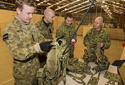 Australian Army officer Major Shane 'Buzz' Sarlin (right) from Diggerworks shows the new 'Tiered Body-Armour System (TBAS) Tier 0 Heavy' harness to soldiers at Exercise Hamel. Photo by Corporal Dan Pinhorn