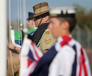 Corporal Owen Brady from Northern Command raises the Aboriginal Flag alongside the raising of the Australian National Flag and the Torres Strait Islander Flag, outside the Officers mess at Darwin's Larrakeyah Barracks to mark the unveiling of plaques and signage at Defence Bases across Darwin to recognise the Larrakeyah People as traditional custodians of the land.