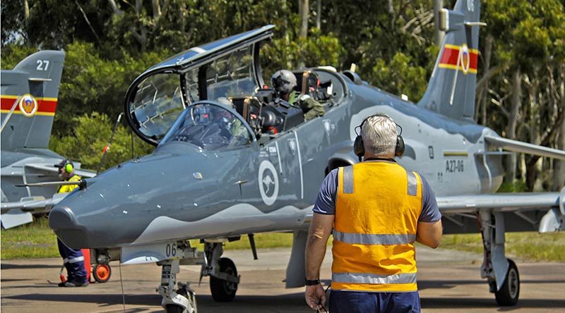 BAE Systems Technician Michael Hickey, communicates with BAE Systems test pilot, Andy Blythe (front Seat) and No 78 Wing test pilot Squadron Leader Michael Physick before their first flight in a modified Hawk-127. Photo by Darren Mottram