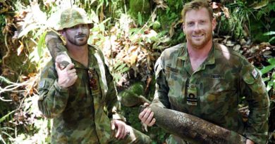 Navy Clearance Divers Petty Officer John Armfield and Lieutenant Robert Kelly carry WWII artillery shells in 'wild country' south of the village of Konga, south-east of Honiara, Solomon Islands.