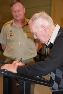 Jack Moore Junior signs over his family’s donation to the Australian Army Museum of Military Engineering while Brigadier Wayne Budd looks on.