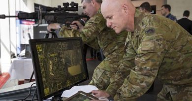 Australian Army officers Major Matt Haar (rear) and Major Shane Sarlin (front) try out the Sword sniper system during Army Innovation Day at the Australian Defence Force Academy in Canberra. Photo by Sergeant Janine Fabre.