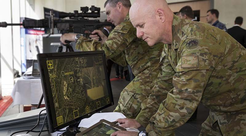 Australian Army officers Major Matt Haar (rear) and Major Shane Sarlin (front) try out the Sword sniper system during Army Innovation Day at the Australian Defence Force Academy in Canberra. Photo by Sergeant Janine Fabre.