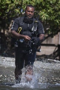 Royal Solomon Islands Police Force officer Simon Ariel Rihia collects explosive remnants of war from shallow waters at Hells Point. Photo by Sergeant Ricky Fuller.