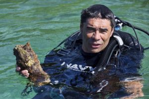 Royal New Zealand Navy's Chief Petty Officer Rangi Ehu surfaces with an unexploded projectile near Yandina. Photo by Corporal Mark Doran.