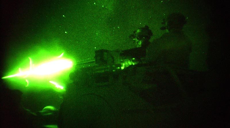 Special Forces Task Group (SFTG) members fire vehicle-mounted heavy weapons at night on a range at a Forward Operating Base (FOB) in Afghanistan. File photo – 2005 – by Sergeant John Carroll.