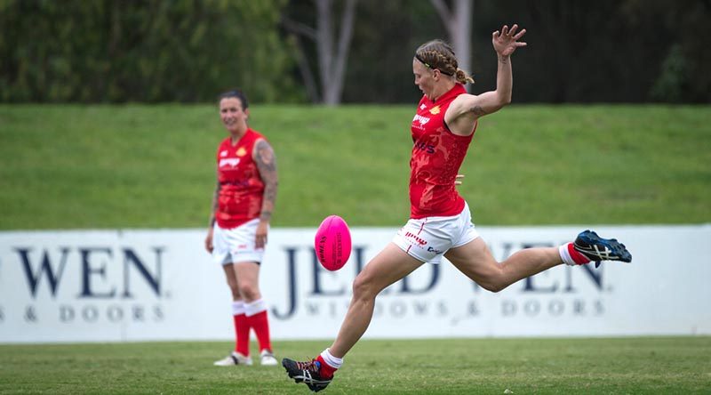 Australian Army soldier Private Kate Lutkins kicks for goal during a match at the ADF Australian Rules Championships in April 2016. Photo by Nunu Campos.