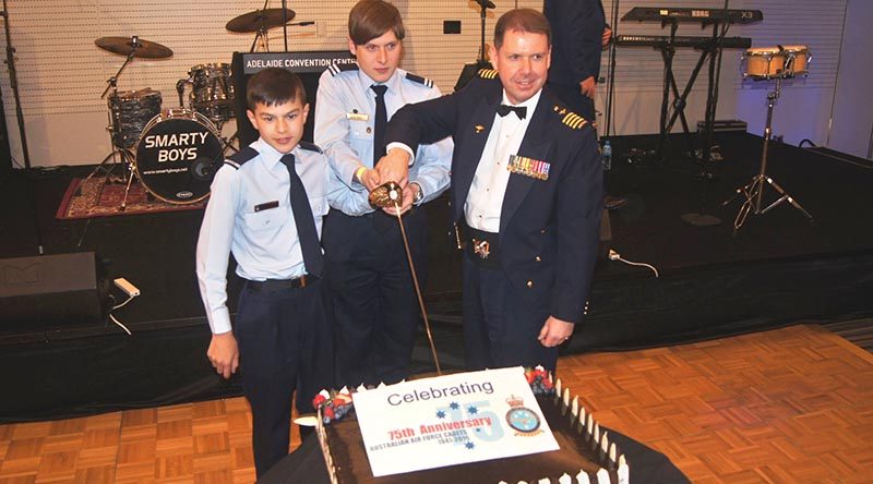 Group Captain Richard Trotman-Dickenson, with the most junior cadet and most senior cadet in uniform Cadet Adomas Neocleous and Cadet Under Officer Lachlan Renfrey, both from 619 (‘City of Onkaparinga’) Squadron at Seaford, cut the anniversary cake.