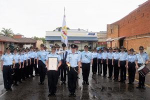 Some of the members of 608 Squadron after the parade, including: the Scroll Bearer, Cadet Corporal Casey Dibben (holding the frame), Parade Commander, Cadet Under Officer Aaron Musk (holding the sword), and Banner Bearer, Cadet Under Officer Hayden Skiparis (partially obscured, holding the banner).